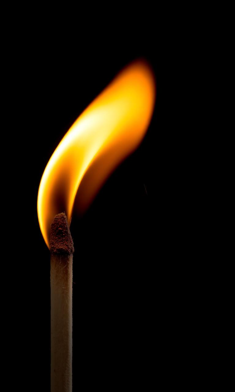 A single matchstick burning against black